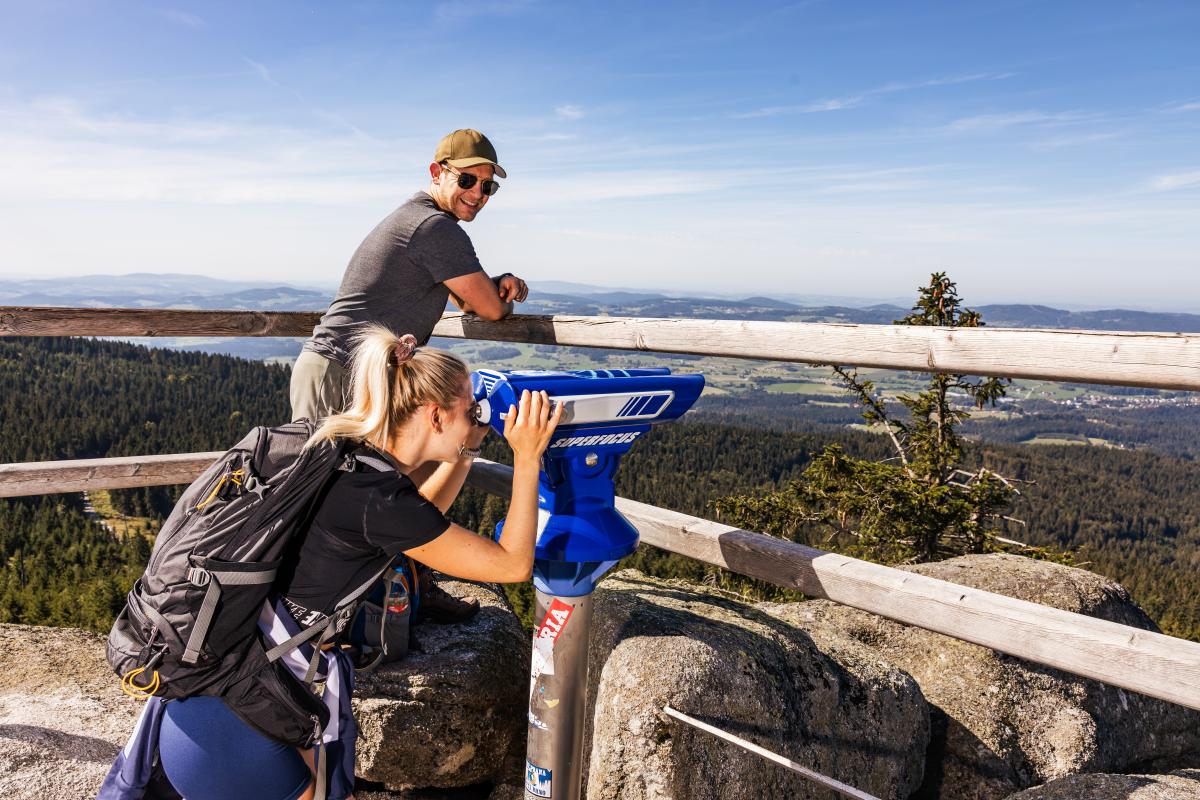 Zwei Frauen wandern und schauen durch ein Fernrohr. Die Szene steht für Tourismus und Freizeit auf dem Land und soll auf ein Seminar der SDL Thierhaupten hinweisen.